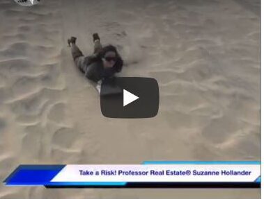 A person is laying in the sand on their back.